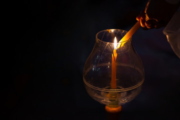 Glittering golden bokeh of burning candles glowing in glass lantern at dark night with full moon. Concept with Buddhism and peace.  