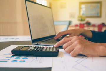 Businessman analysis on Graph data paper  using calculator, finance concept in office.