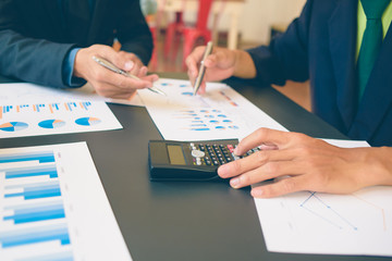 Businessman analysis on Graph data paper  using calculator, finance concept in office.