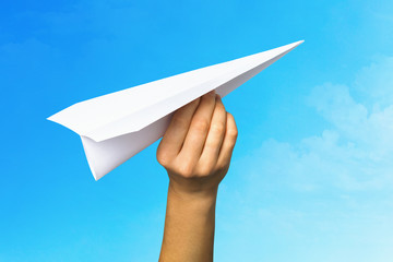 Concept on the topic of starting a new business and striving forward. Man launches a paper plane into the sky