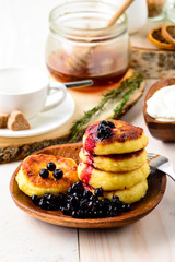 Fritters of cottage cheese with blueberries in plate, closeup