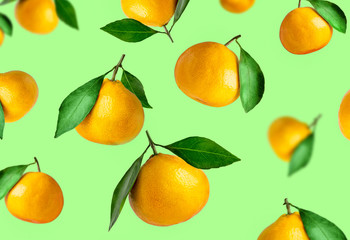 Tangerines of different shapes with leaf on a colored background isolated. Tangerines flying in the air. Christmas composition of a tangerines orange with leaves.