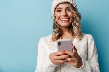 Portrait of caucasian excited woman smiling and using cellphone