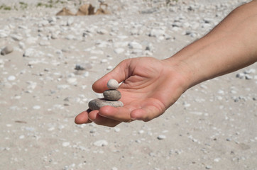 Stacked pebble stones in man's hand