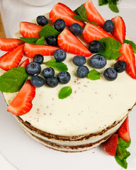 dessert with strawberries. White cake with strawberries and blueberries.