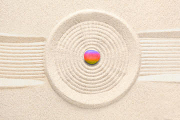 rainbow colors zen stone on raked sand with copy space for your text