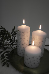 Three snowflake candles and christmas decorations