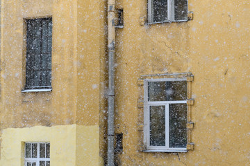Fototapeta na wymiar View to courtyard in Saint-Petersburg from window in winter time, snow fall