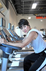 Female beauty working on machines in a health club.