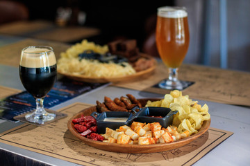 glass of beer and snacks on table