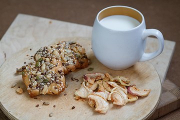 cookies with sunflower seeds and milk in white cup and dried fruits