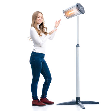 Woman warms near an electric infrared heater on white background isolation
