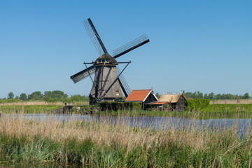 Fototapeta na wymiar Netherlands rural village scenic view - windmills at famous tourist site Kinderdijk in Holland. Kinderdijk , Netherlands