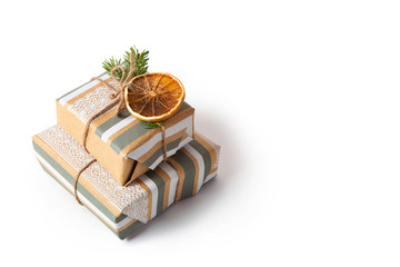New Year decoration. Gifts packed in craft paper on a white isolated background. Fir branches and cone. Copy space