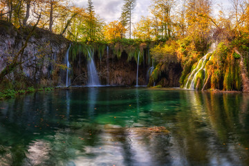 Plitvice lakes (Plitvicka jezera) national park, Croatia. Amazing autumn sunny landscape with waterfall Mali Buk, Gradinsko lake, colored trees and sky. Outdoor travel background, famous landmark