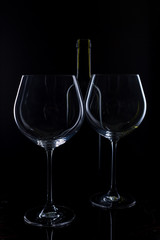  glass of red and pink wine on a black background. Wine list menu. Close up of the power of glasses and bottles in low key