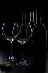  glass of red and pink wine on a black background. Wine list menu. Close up of the power of glasses and bottles in low key