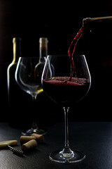  glass of red and pink wine on a black background. Wine list menu. Close up of the power of glasses and bottles in low key