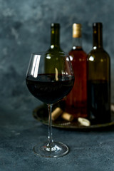 Red wine. Bottle and glass of red wine. Vintage style. Red wine on a black background. Design with space for your text.