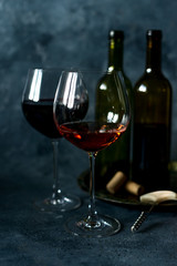 Red wine. Bottle and glass of red wine. Vintage style. Red wine on a black background. Design with space for your text.