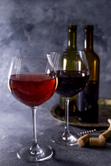 Red wine. Bottle and glass of red wine. Vintage style. Red wine on a black background. Design with space for your text.