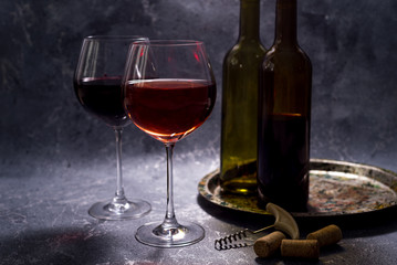 Red wine. Bottle and glass of red wine. Vintage style. Red wine on a black background. Design with space for your text.