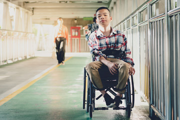 Portrait of Disabled child on wheelchair, Public bridge background with blurry, Special children’s enjoying outdoor activity at a normal life,Life in the education age ,Happy disability kid concept..