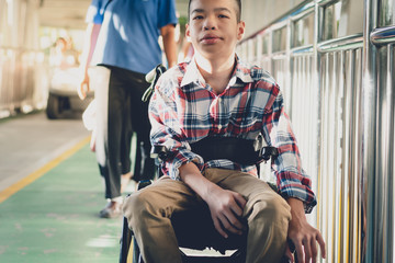 Portrait of Disabled child on wheelchair, Public bridge background with blurry, Special children’s enjoying outdoor activity at a normal life,Life in the education age ,Happy disability kid concept..