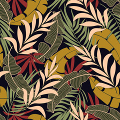 Fashionable seamless tropical pattern with bright yellow and red plants and leaves on black background. Modern abstract design for fabric, paper, interior decor.  Summer colorful hawaiian.