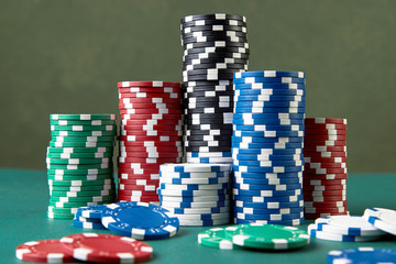 Poker gambling chips on green background with copy space.
