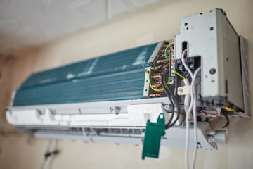 Split air conditioner closeup repair and maintenance concept. The specialist repairs the wall air...