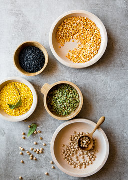Overhead view of various lentils and beans in wooden bowls