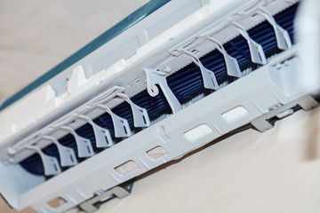 Fototapeta premium Split air conditioner closeup repair and maintenance concept. The specialist repairs the wall air conditioner. Inverter Air conditioning service