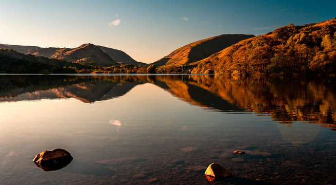Grasmere Lake reflections in the Lake District in autumn. Sunset over beautiful still lake in Cumbria, England, UK.