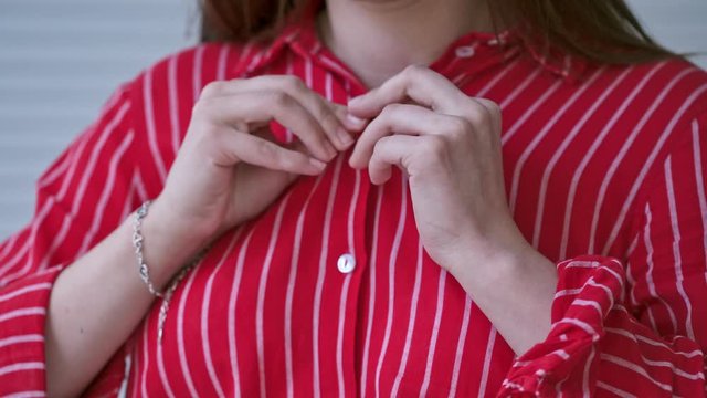 Woman hands close up buttons on shirt. Close up of hand woman adjusting shirt button