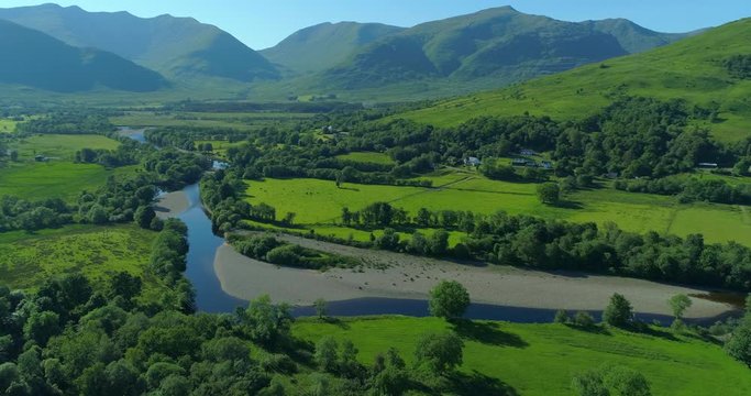 Gently tracking aerial of the River Orchy in Dalmally, Argyll in the Scottish Highlands on a summer's day with mountains in the background