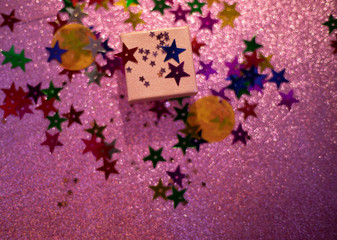 sparkly pink background with small gift box and star shaped glitters