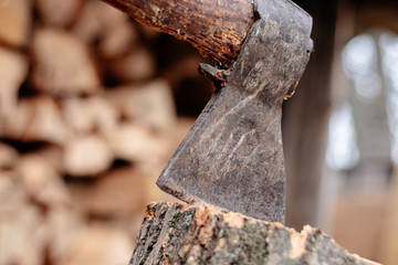 An ax stuck in a log. Ax blade close.