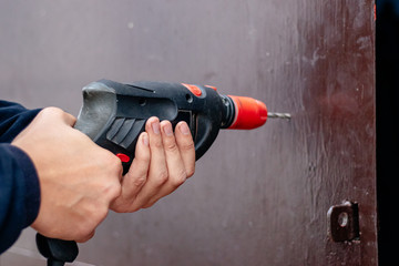 Hands of a man drills with an electric drill