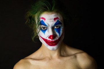 Portrait of a man with clown makeup and green hair, Cosplay.