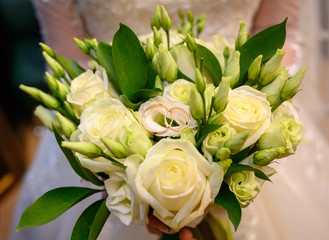 bouquet of white roses and gold rings