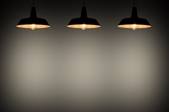 Black hanging lamp illuminate to black background, background concept.