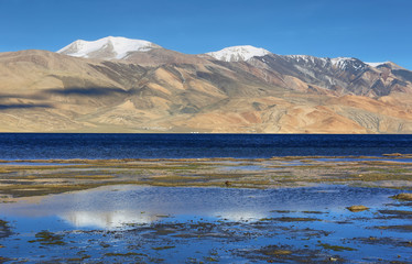 Reflection of Tso Moriri lake in Rupshu valley with Chamser and Lungser Kangri peaks at background in Ladakh, India