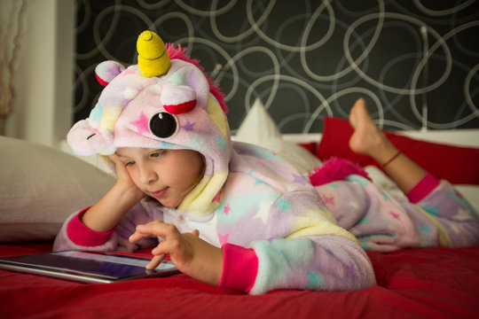 Girl using tablet on bed