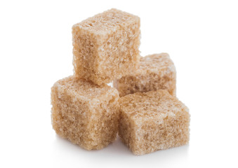 Close-Up shot of natural brown sugar cubes on white background.