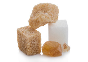 Cubes of natural brown and white and caramelized unrefined sugar cubes on white background.Macro