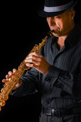 soprano saxophone in the hands of a guy on a black background