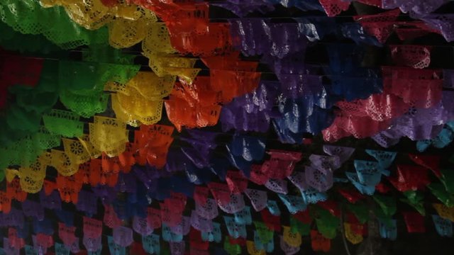 decorative handcrafted colorful pecked paper on stripes hanging on the sky with the name of the mexican state Tlaxcala engraved
