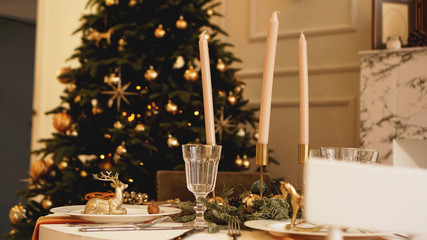 Table with candles served for Christmas dinner in living room, close up view