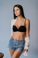 Sexy body women wear denim shorts and black lingerie dark grey background studio indoor